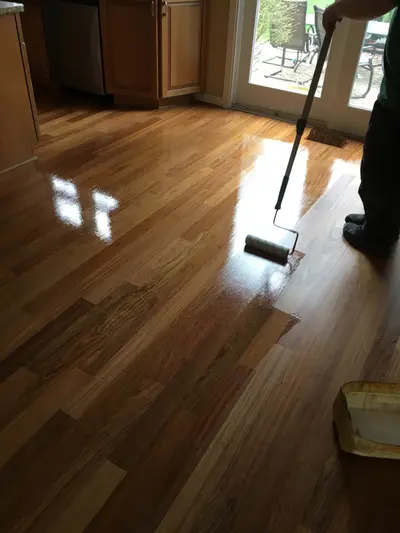 Hardwood floor finishing process – roller application | FLOORecki Hardwood floor finishing in progress with a roller application by a FLOORecki technician in a Chicago home