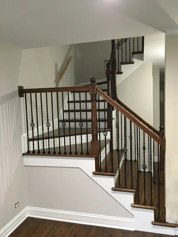 Dark stained staircase with white risers – Winnetka | FLOORecki Floors & Stairs Dark stained stairs with white risers and skirts, square posts and handrails, and black iron spindles in a Winnetka home