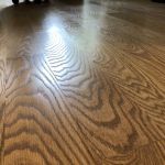 Close up of hardwood flooring with a light brown stain and satin polyurethane finish in a Chicago home 