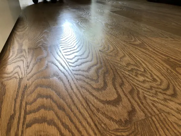 Light brown stained hardwood floor with satin finish – FLOORecki Close up of hardwood flooring with a light brown stain and satin polyurethane finish in a Chicago home