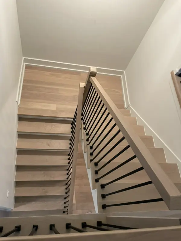 White oak staircase with square treads and black iron spindles – FLOORecki Floors & Stairs White oak square stair treads with plain square posts, handrails, and black iron spindles installed in a Chicago home