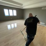 FLOORecki technician applying a finish coat during hardwood floor refinishing in a Chicago home 