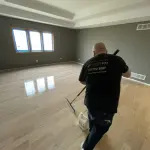 FLOORecki technician applying a finish coat during hardwood floor refinishing in a Chicago home 