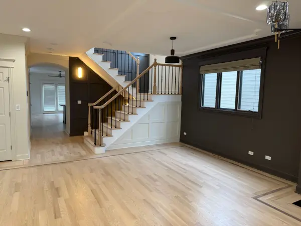 White Oak Floors & Stair Refinishing in Chicago | FLOORecki Floors & Stairs White oak hardwood floors with a refinished staircase, square posts, and black iron spindles in a Chicago home