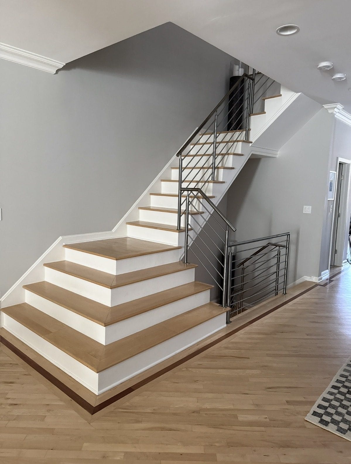 Dated orange-toned oak floor and maple staircase before refinishing in a Chicago home
